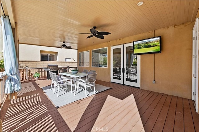 wooden terrace featuring outdoor dining space, french doors, and ceiling fan