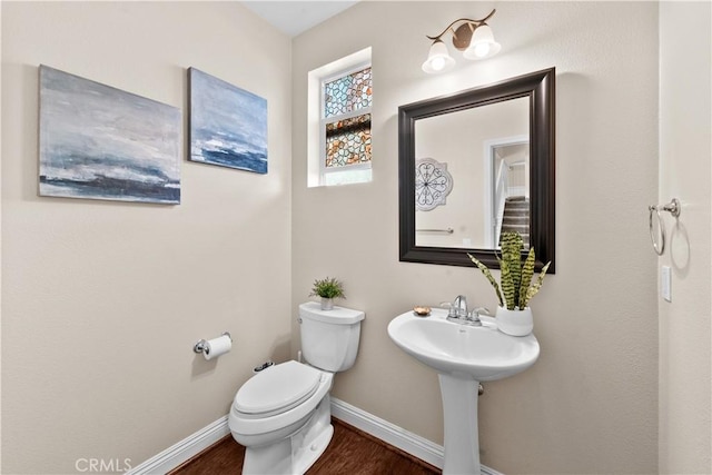 bathroom featuring wood finished floors, toilet, and baseboards