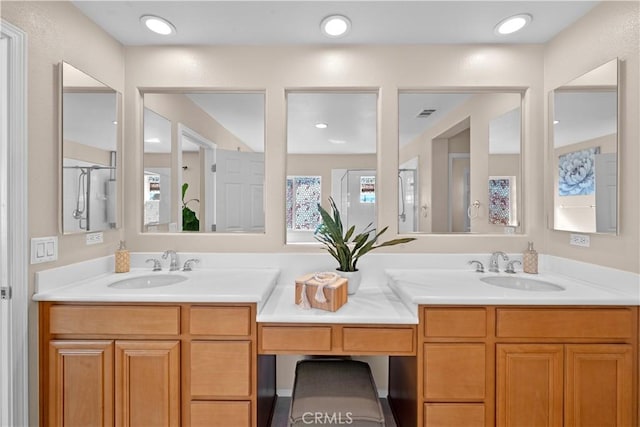 bathroom featuring recessed lighting, a sink, and double vanity