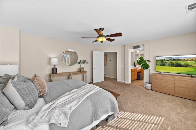 carpeted bedroom featuring connected bathroom, visible vents, and a ceiling fan