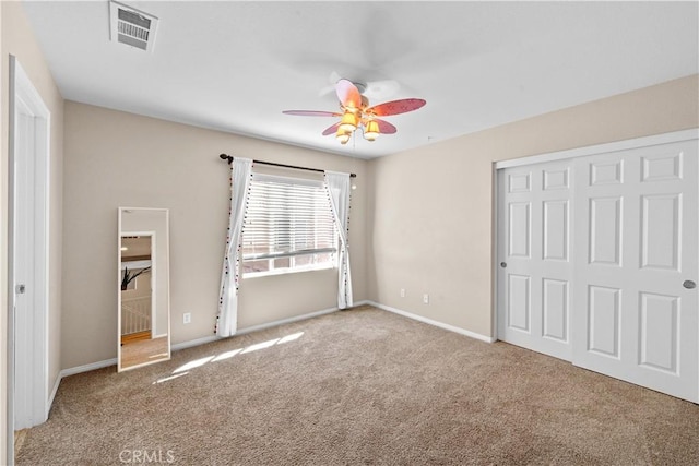 unfurnished bedroom featuring a closet, visible vents, baseboards, and carpet flooring