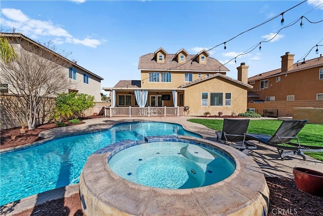 view of swimming pool with a pool with connected hot tub, a fenced backyard, and a patio