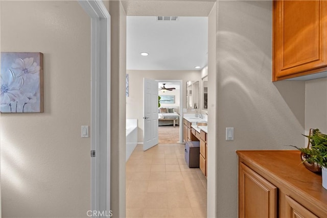 interior space featuring recessed lighting, visible vents, connected bathroom, vanity, and a bath