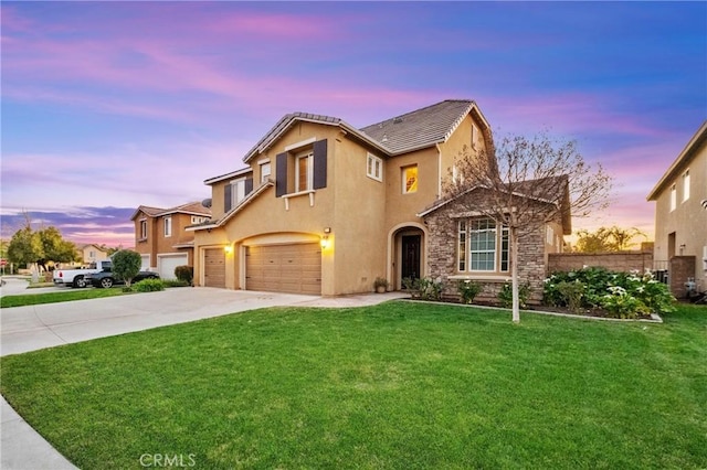 traditional-style home featuring an attached garage, stucco siding, concrete driveway, and a yard