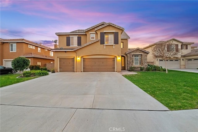 traditional home with driveway, a front lawn, an attached garage, and stucco siding