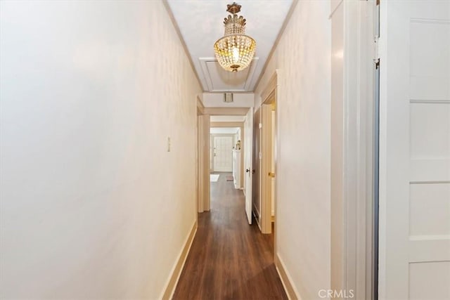 hallway with attic access, baseboards, and dark wood-type flooring