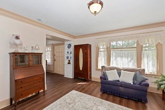 living area featuring dark wood-style floors, visible vents, crown molding, and baseboards