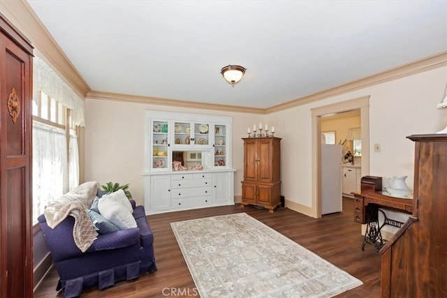 living area featuring baseboards, dark wood finished floors, and crown molding