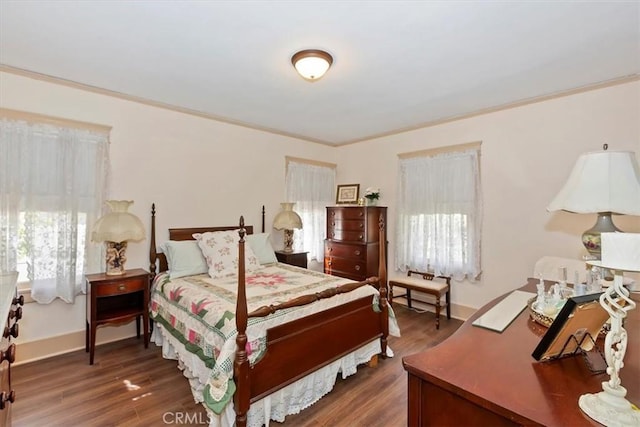 bedroom featuring ornamental molding, dark wood finished floors, and baseboards