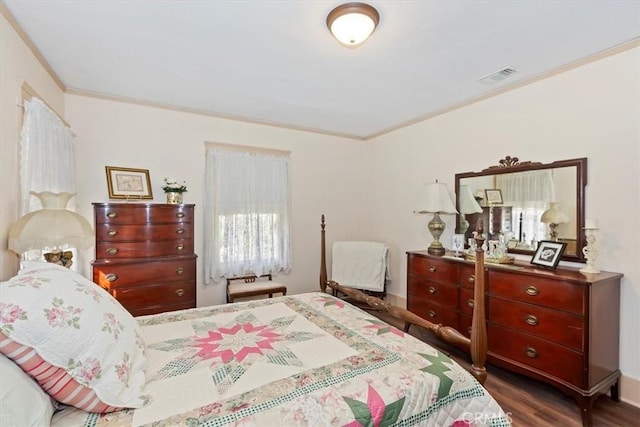 bedroom with dark wood-style floors, visible vents, and crown molding