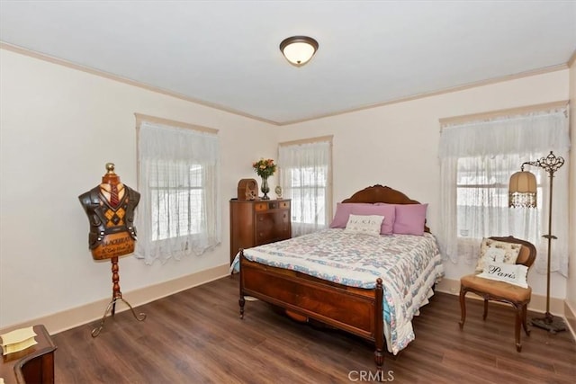 bedroom featuring ornamental molding, dark wood-style flooring, and baseboards