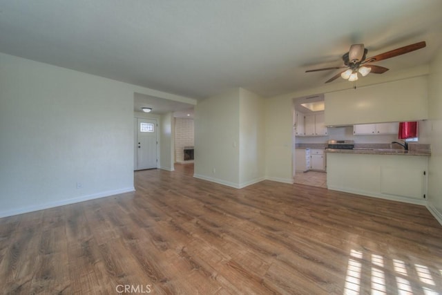 8371 Hawthorne St, Rancho Cucamonga, CA 91701 - unfurnished living room featuring wood finished floors, ceiling fan, and a brick fireplace