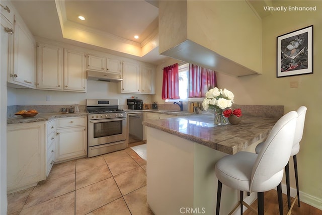 8371 Hawthorne St, Rancho Cucamonga, CA 91701 - kitchen with appliances with stainless steel finishes, under cabinet range hood, a peninsula, a tray ceiling, and recessed lighting