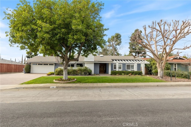 ranch-style house featuring driveway, an attached garage, fence, and a front yard