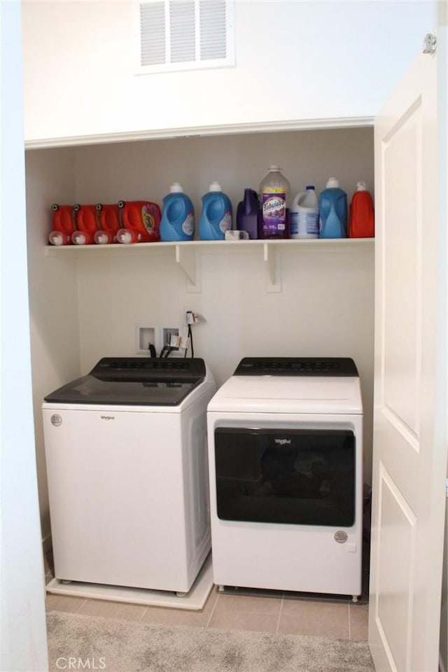 laundry area with washer and dryer, laundry area, visible vents, and light tile patterned floors