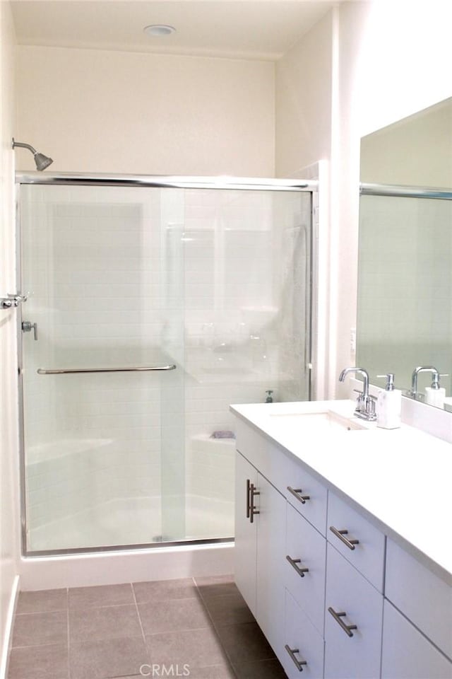 full bathroom featuring tile patterned flooring, a shower stall, and vanity