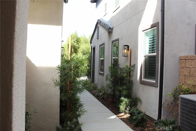 view of home's exterior with central AC and stucco siding