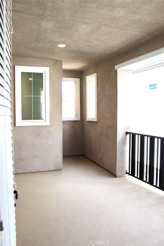 unfurnished room with a textured ceiling and light colored carpet