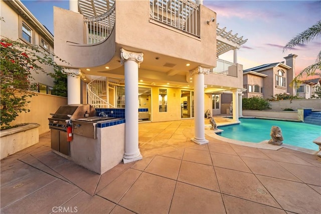 pool at dusk featuring a patio area, area for grilling, and an outdoor pool