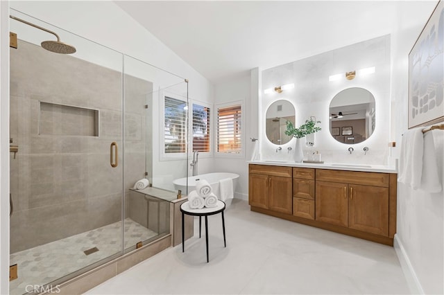 bathroom featuring double vanity, a freestanding bath, a stall shower, vaulted ceiling, and a sink