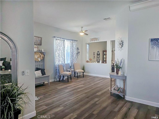 sitting room with ceiling fan, dark wood-style flooring, visible vents, and baseboards