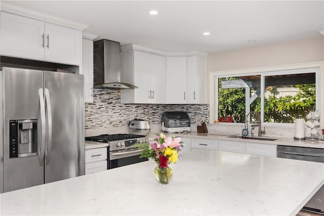 kitchen featuring a sink, wall chimney range hood, stainless steel appliances, and backsplash