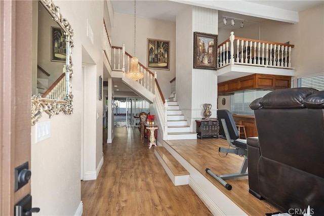 interior space with stairs, a high ceiling, and wood finished floors