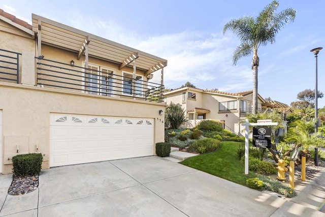 view of front of house with concrete driveway, a balcony, an attached garage, and stucco siding