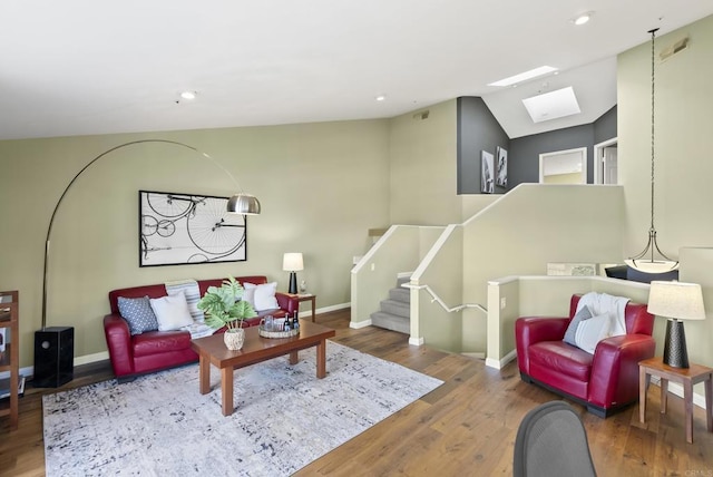 living area featuring baseboards, stairway, and wood finished floors