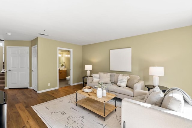 living area featuring wood finished floors, visible vents, and baseboards