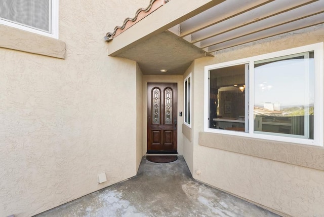 entrance to property featuring stucco siding