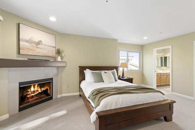 bedroom featuring light carpet, recessed lighting, a fireplace, and baseboards