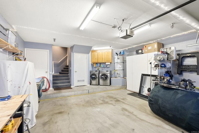 garage with strapped water heater, washer and dryer, and a garage door opener