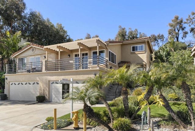 view of front of home with stucco siding, driveway, a pergola, a garage, and a balcony