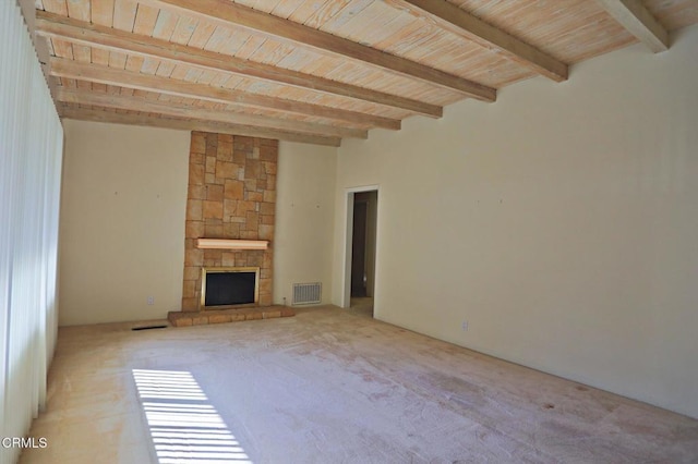 unfurnished living room featuring light carpet, visible vents, wooden ceiling, beamed ceiling, and a stone fireplace