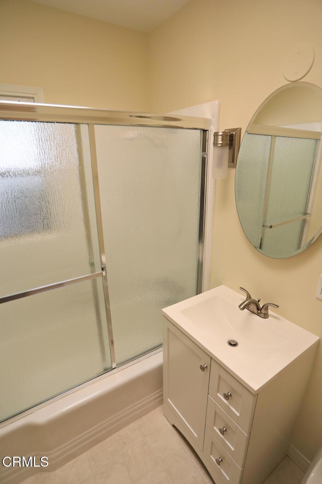 full bathroom featuring combined bath / shower with glass door and vanity