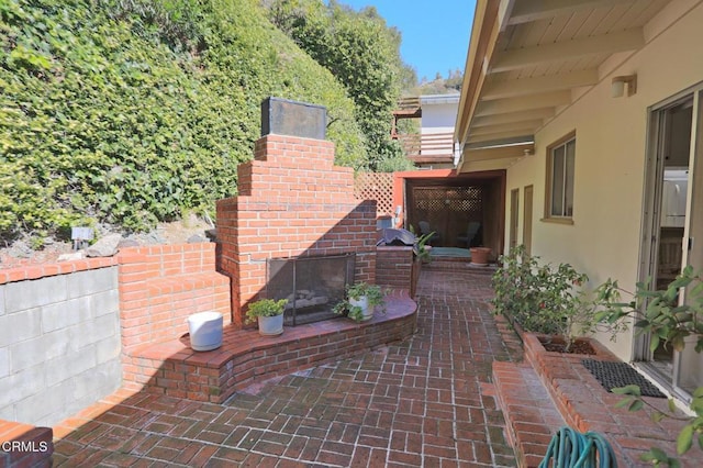 view of patio featuring an outdoor brick fireplace