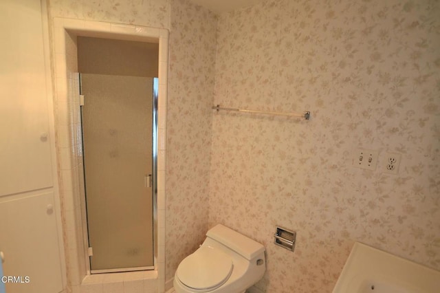 full bath featuring toilet, wallpapered walls, and a stall shower