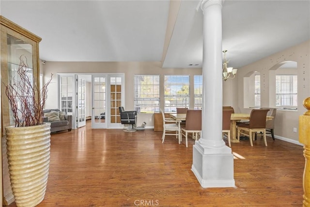 interior space featuring a wealth of natural light, a notable chandelier, baseboards, and wood finished floors