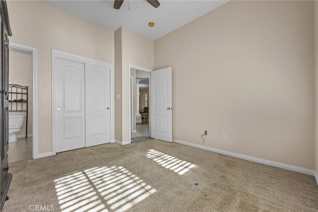 unfurnished bedroom with light carpet, ceiling fan, a closet, and baseboards