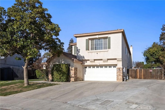 traditional-style house with an attached garage, brick siding, fence, concrete driveway, and stucco siding