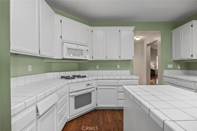 kitchen with tile counters, white appliances, white cabinetry, and dark wood-style flooring