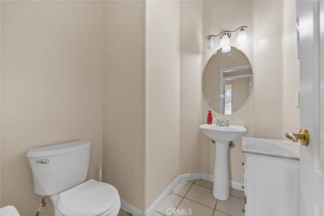 half bathroom with baseboards, toilet, and tile patterned floors