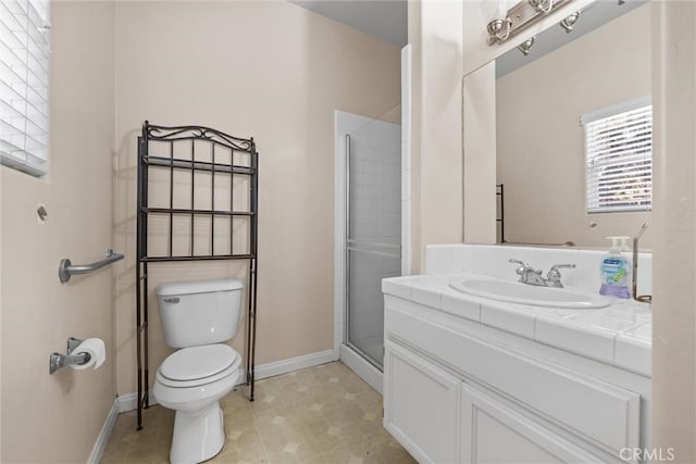 full bathroom with vanity, a shower stall, toilet, and baseboards