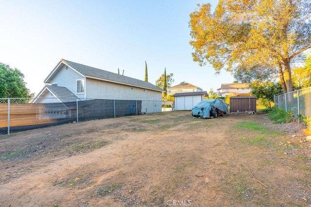 view of yard with a storage unit and fence