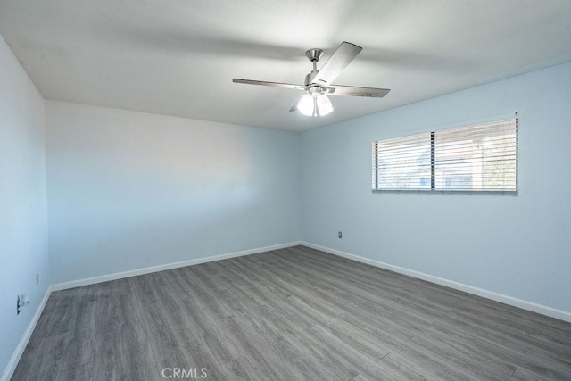 empty room featuring dark wood-style floors, a ceiling fan, and baseboards