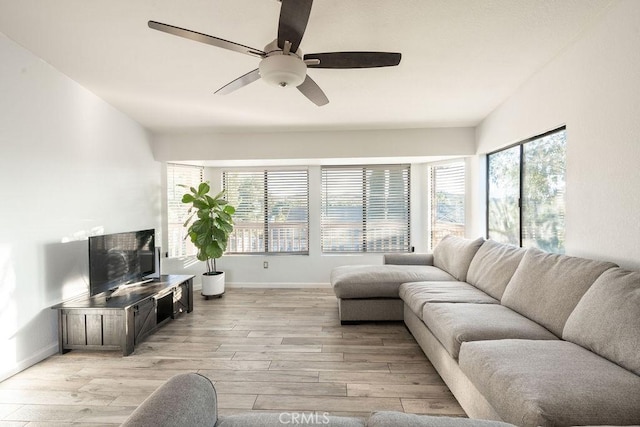 living room with a ceiling fan, light wood-type flooring, and baseboards