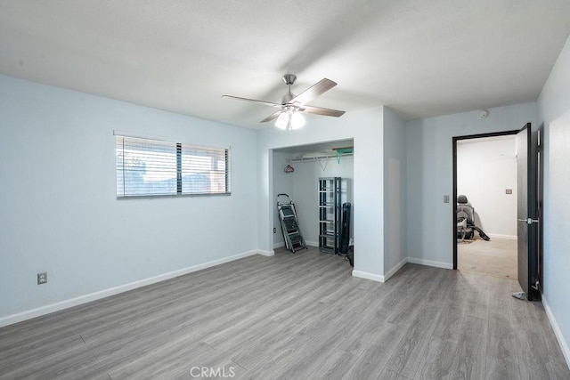 unfurnished room featuring light wood-type flooring, baseboards, and a ceiling fan