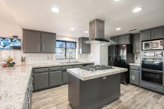 kitchen with island range hood, a sink, visible vents, gray cabinets, and black appliances