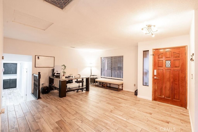 interior space with light wood-style floors, visible vents, and baseboards